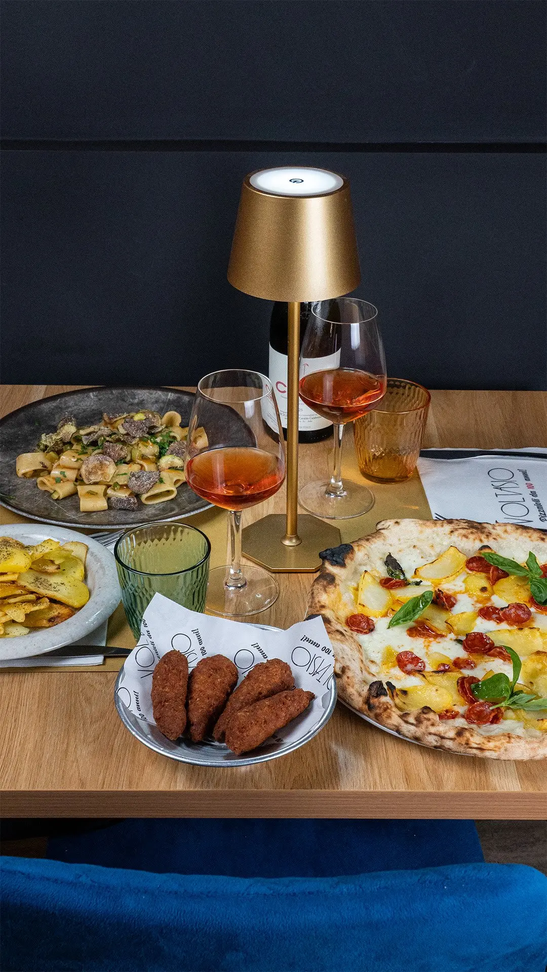 Il tavolo apparecchiato con pizza, pasta e fritti